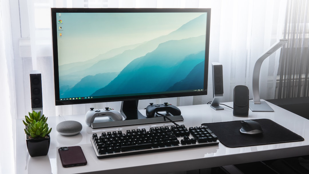 computer monitor in front of a window with white curtains